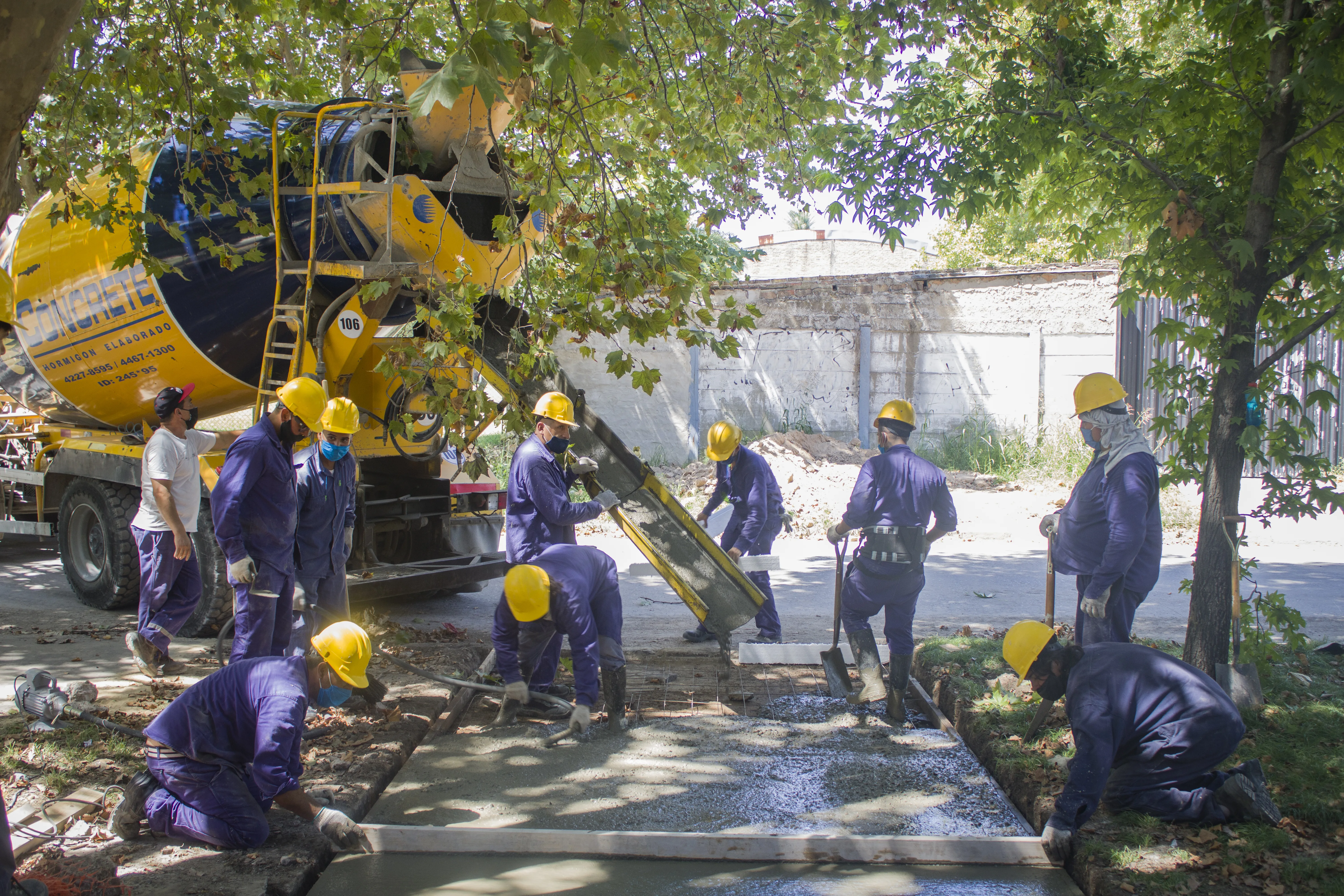 Equipo de trabajadores reunido alrededor de una obra de pavimentación