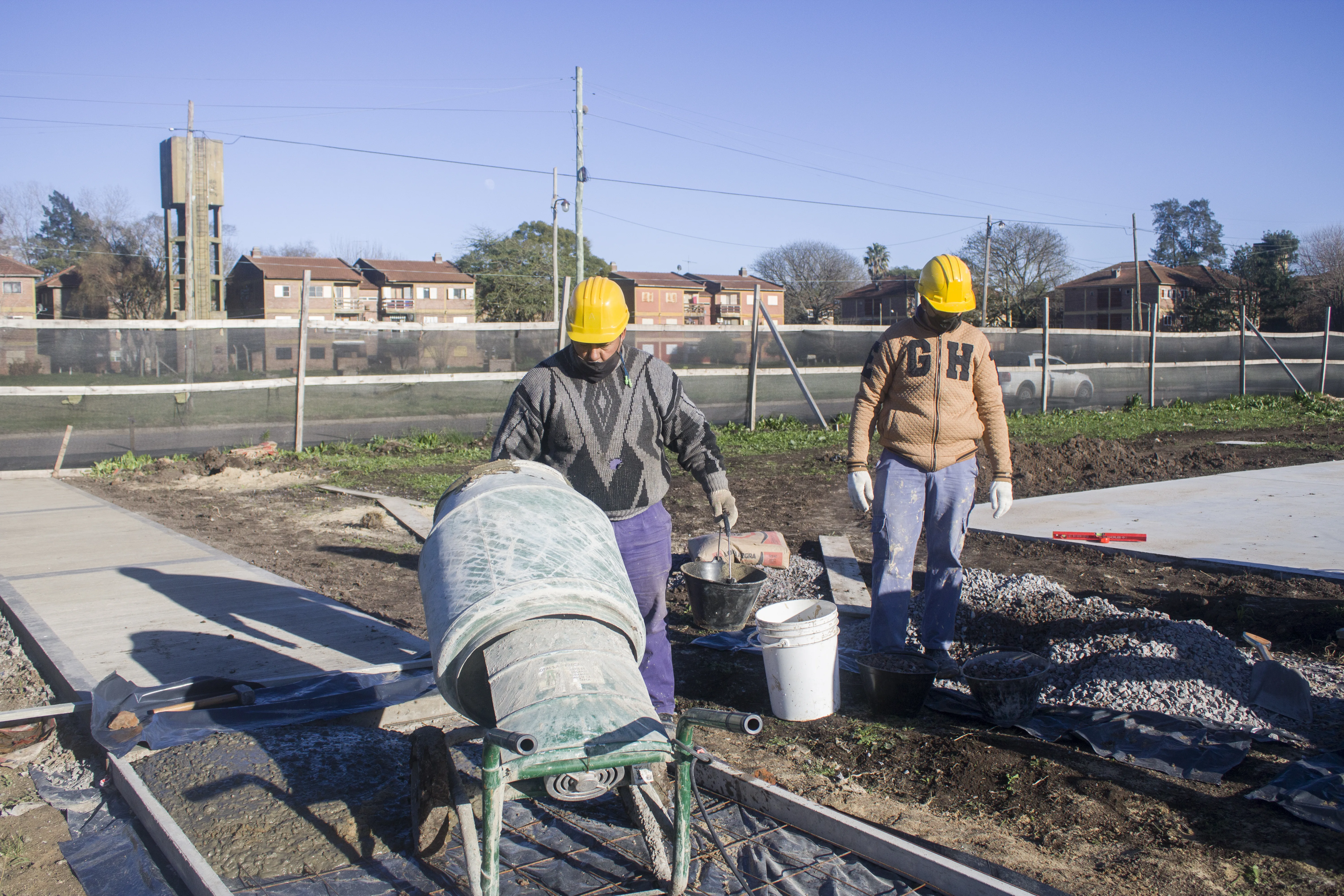 Trabajadores preparando mezcla en una obra al aire libre