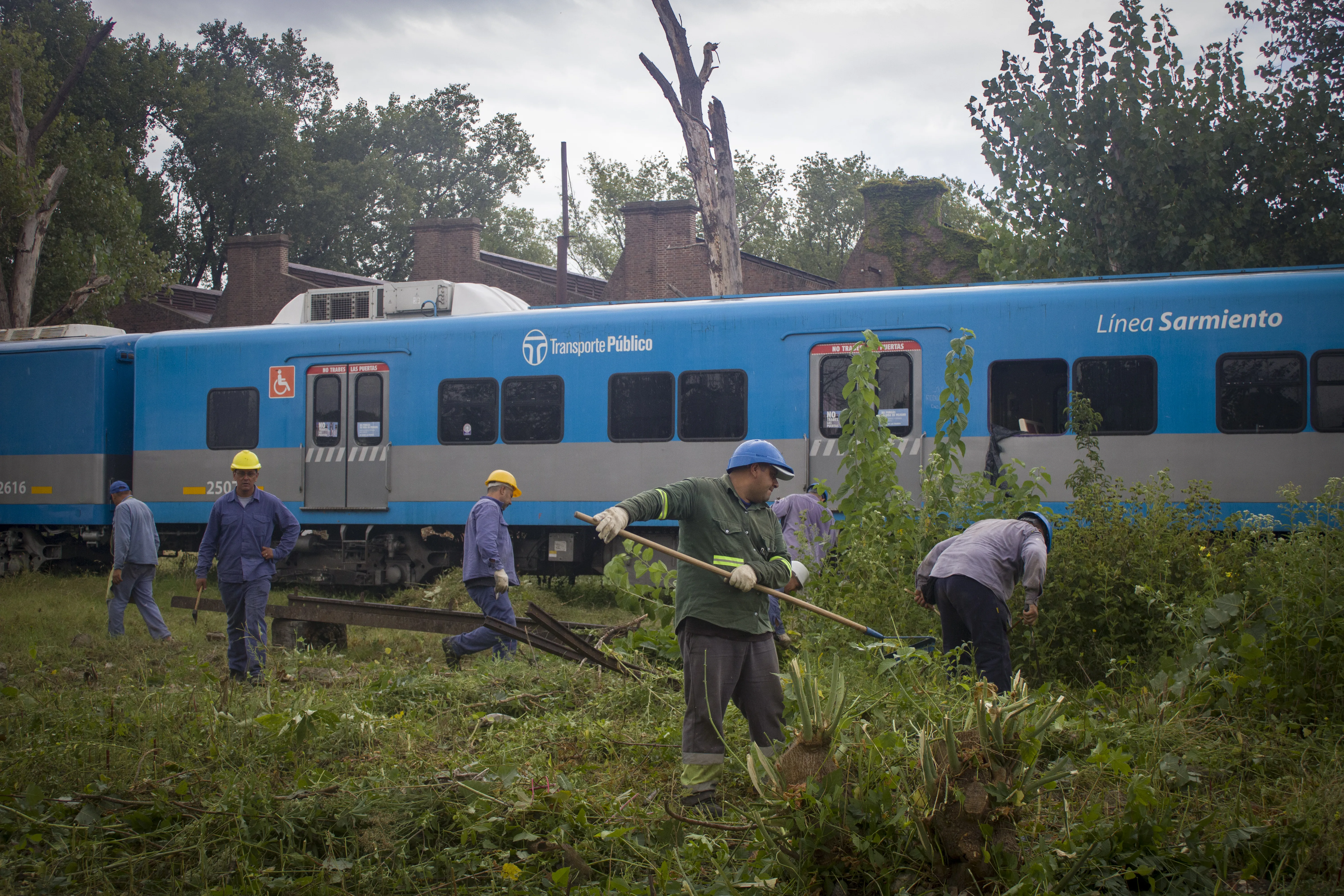 Trabajadores realizando tareas de mantenimiento junto a las vías del tren