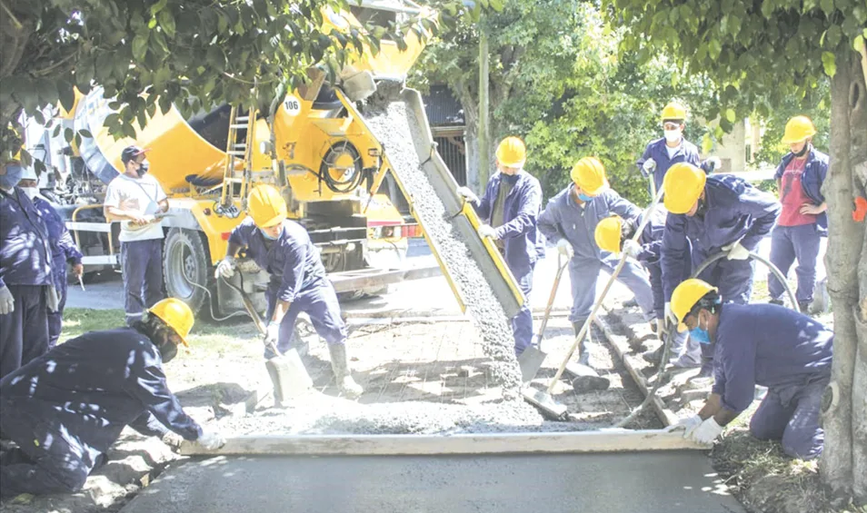 Equipo de trabajadores preparando una vereda con hormigón